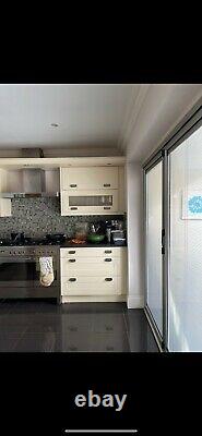 Cream kitchen units with silver handles and island with black granite worktop